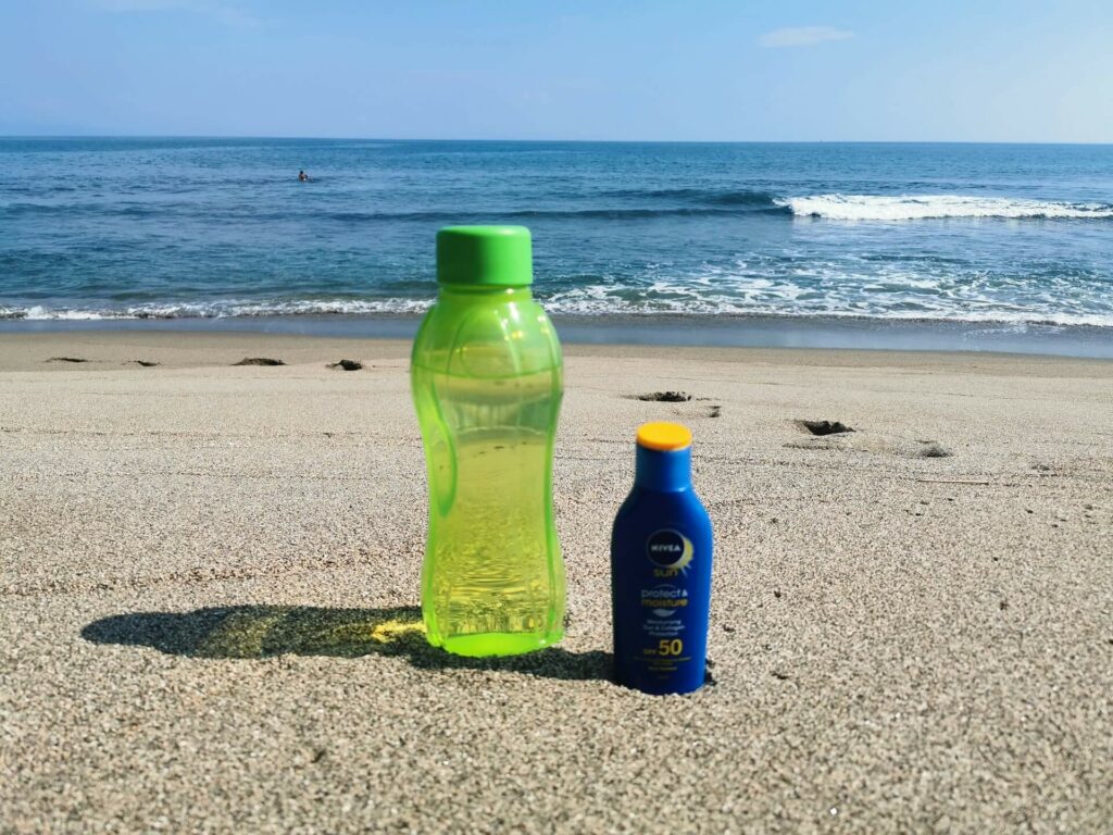 water bottle and sunscreen for beach shoot